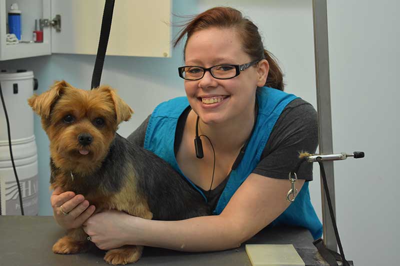 A happy dog with their groomer at Bone-a-Fido Bakery